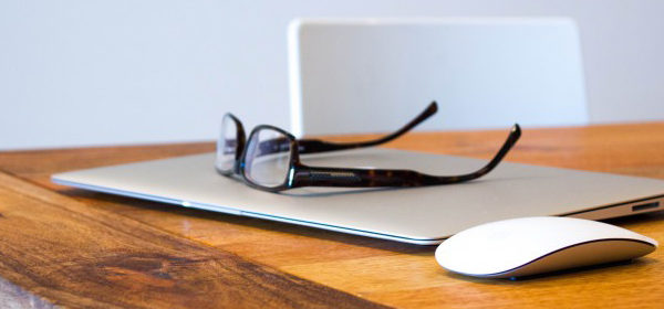 Laptop Maus und Brille auf dem Tisch