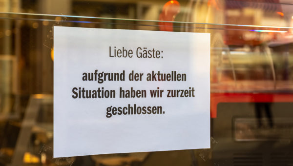 Schild mit Hinweis auf Schließung am Eingang eines Geschäfts